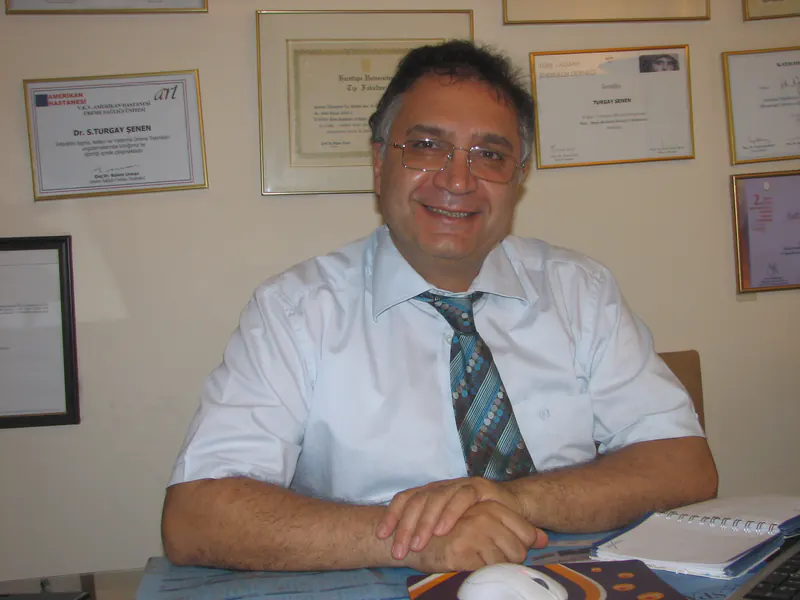 Op. Dr. S. Turgay Şenen muayenehanesinde, diploma ve sertifikalarının önünde